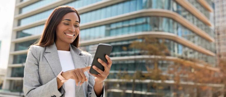 African businesswoman using a mobile phone for digital financial transactions, representing Kenya’s mobile money ecosystem and financial innovation.
